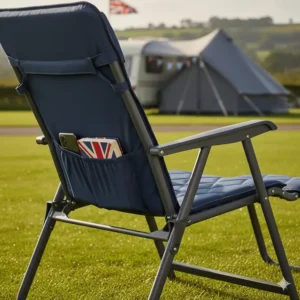 Detail shot of a camping chair with footrest showing a side storage pocket containing a book and a mobile phone.