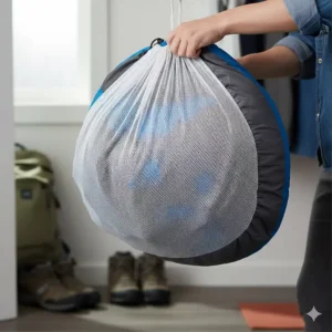 A summer sleeping bag being stored loosely in a mesh storage sack to maintain loft and insulation quality.
