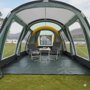 The spacious interior of a tall motorhome awning featuring a dining table, chairs, and large windows looking out over a British lake.