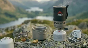 Close-up of a hiker adjusting the simmer control on a backpacking stove while cooking a fresh meal.