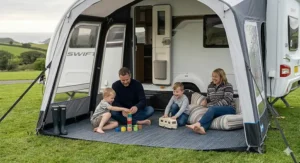 Rinsing mud off a breathable awning carpet with a hose to show easy maintenance for UK weather conditions.
