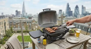 A sleek portable gas BBQ being used on an urban London balcony with a view of the Shard and the city skyline.