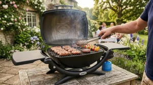 A detailed top-down photorealistic close-up of a Weber portable gas BBQ with its lid open, covered in sizzling British beef burgers and pork sausages, with a pair of stainless steel tongs turning food on the cast iron grate.