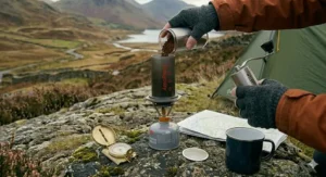 Flat lay of essential camping coffee gear for one person, including a small stove and portable filter.