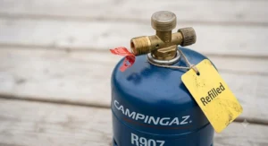 Close-up of a Campingaz R907 refill cylinder showing the safety valve mechanism.