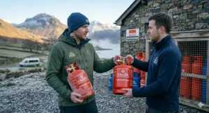 A camper and a shop assistant exchanging an empty gas bottle for a full one at a UK retailer.