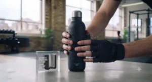 Ergonomic, sweat-proof exterior finish providing a non-slip grip on a gym water bottle during heavy lifting.