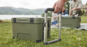 Technical detail of a wheeled personal cool box with an ergonomic telescopic handle.