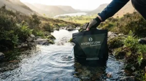 Collecting raw water from a stream to use with a gravity water filter for large groups on a camping trip.