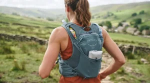 Trail runner navigating a rocky ridge with a bounce-free running vest hydration pack.