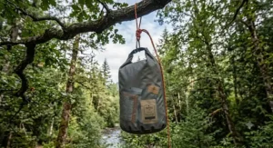 Lightweight dry bag packed with three days of camping food and freeze-dried meals next to a camping stove.