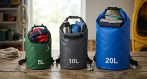 Comparison of 5L, 10L, and 20L dry bags for kayaking filled with essential British paddling gear like a cagoule and flask.