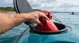 Tapered dry bag being pushed easily into the stern rubber hatch of a sea kayak.