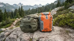 An odour-proof food sack laid out on a rock beside a standard dry bag for food storage comparison.